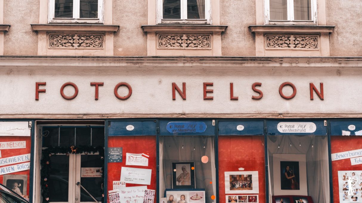 Das Schild "FOTO NELSON" an einem Geschäft mit rotem und blauem Farbschema.