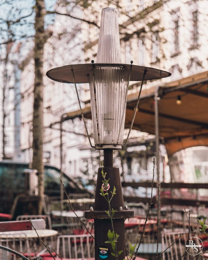 Gartenlaterne vor einem Restaurant mit Tischen im Freien.