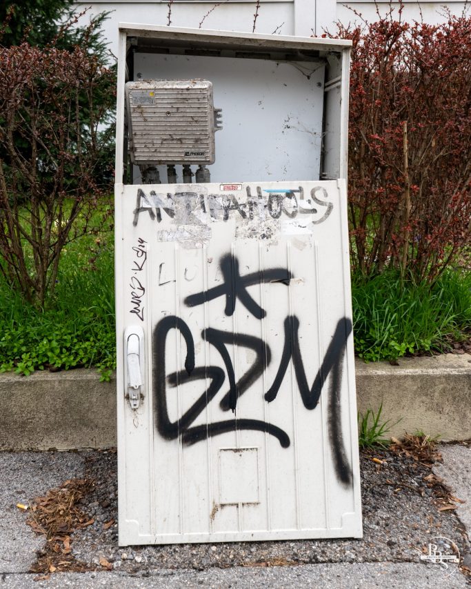 Graffiti auf einer grauen elektrischen Verteilungstafel mit dem Schriftzug "BDM".